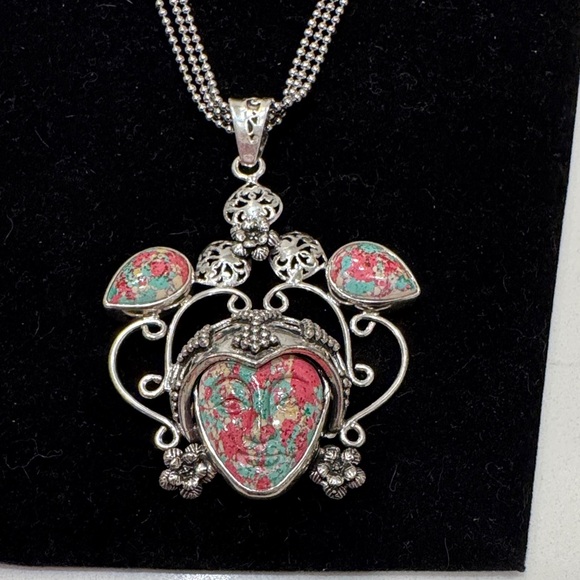 Carved gemstone face set within a decorative silver frame Pendant Necklace